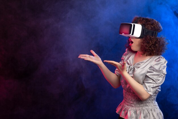 Junge Frau mit Virtual-Reality-Headset auf dunklen, rauchigen Spielvideos