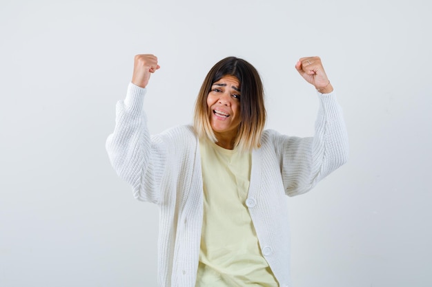 Kostenloses Foto junge frau mit weißer strickjacke gewinnt