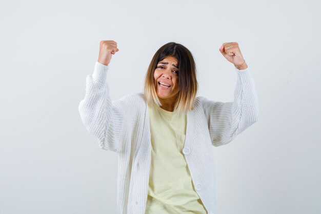 Junge Frau mit weißer Strickjacke gewinnt