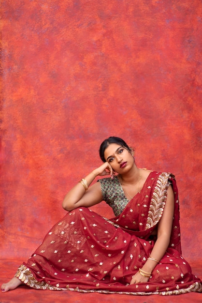 Junge Frau posiert beim Tragen eines traditionellen Sari-Kleidungsstücks