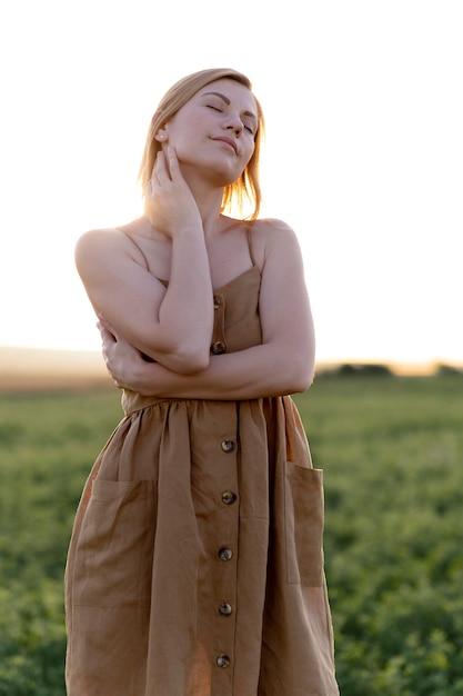 Junge Frau posiert im Freien auf einem Feld