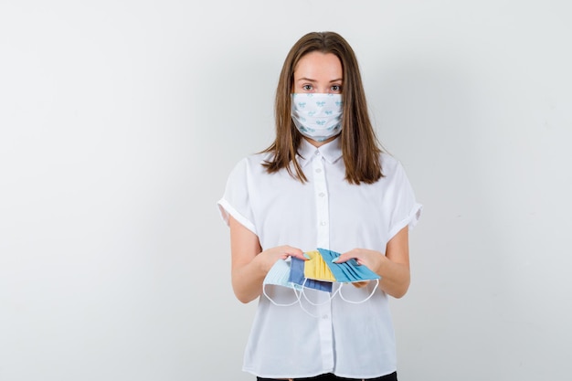 Junge Frau präsentiert medizinische Masken