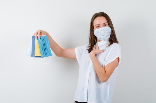 Junge Frau präsentiert medizinische Masken