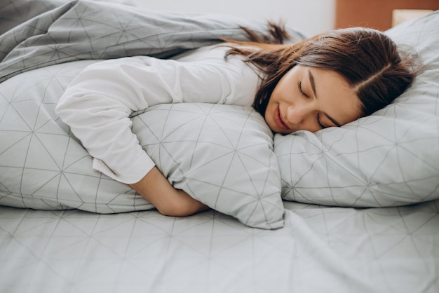 Junge Frau schläft in ihrem Bett