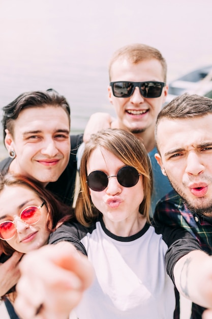 Junge Frau schmollend unter Selfie mit lächelnden Freunden