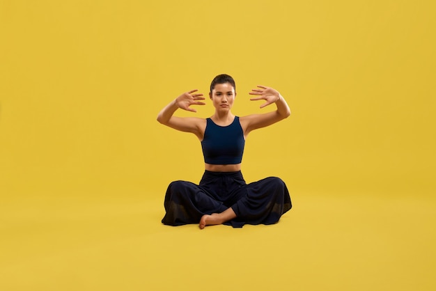 Junge Frau sitzt auf dem Boden und macht Yoga