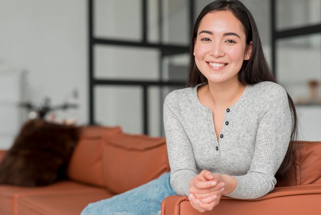 Junge Frau sitzt auf der Couch