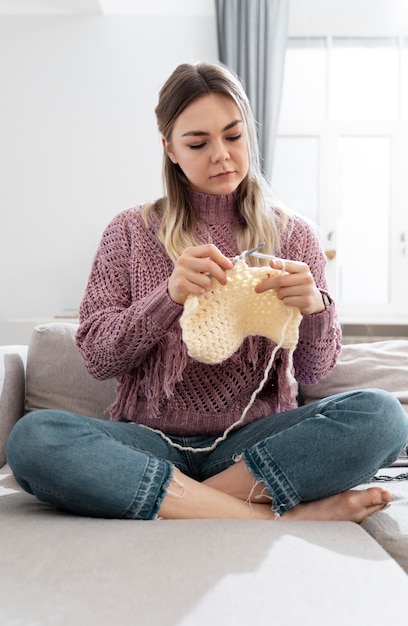 Kostenloses Foto junge frau strickt beim entspannen