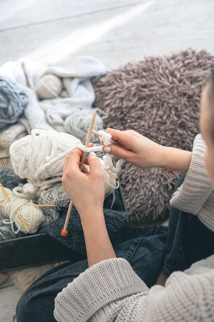 Kostenloses Foto junge frau strickt zu hause einen warmen pullover