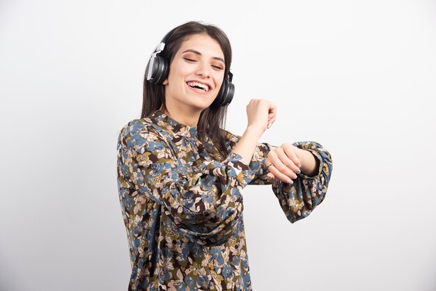Junge Frau tanzt und hört Musik in Kopfhörern.