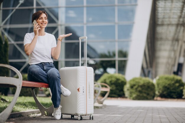 Junge Frau telefoniert am Flughafen