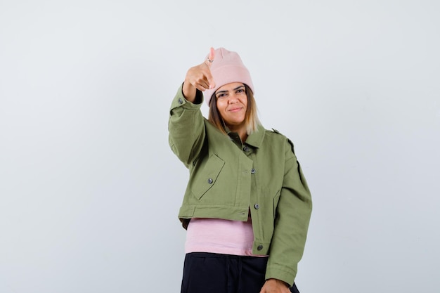 Junge Frau trägt eine Jacke und einen rosa Hut