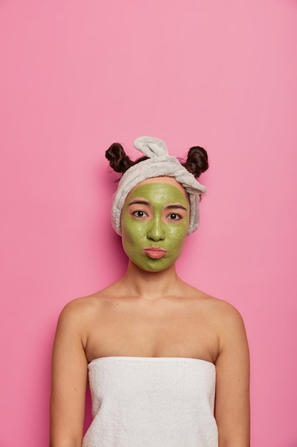 Junge Frau trägt natürliche Gesichtsmasken-Hautbehandlungen nach dem Baden