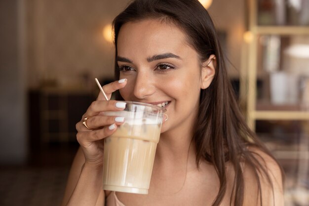 Junge Frau trinkt Eiskaffee