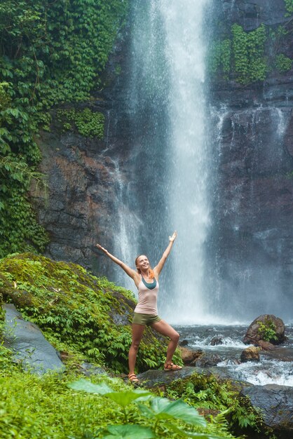 Junge Frau übt Yoga am Wasserfall