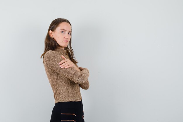 Junge Frau umarmt sich in Bluse, Rock und sieht besorgt aus. . Platz für Text