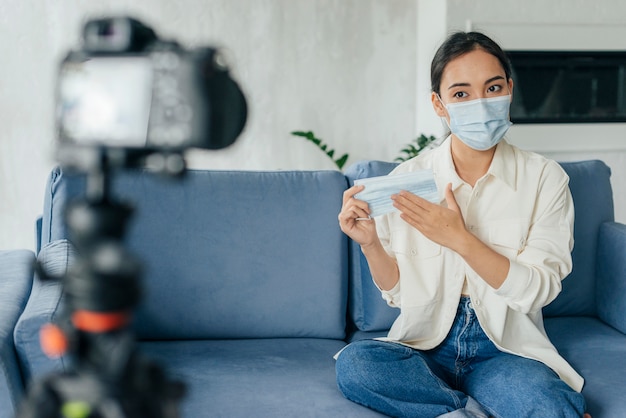 Kostenloses Foto junge frau vlogging über gesichtsmasken