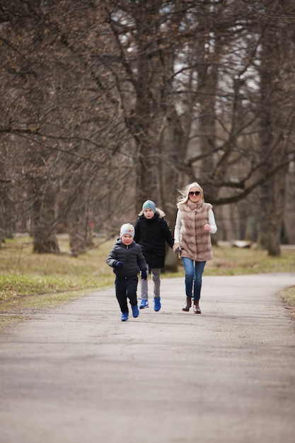 Kostenloses Foto junge frau zu fuß mit ihren kindern im park