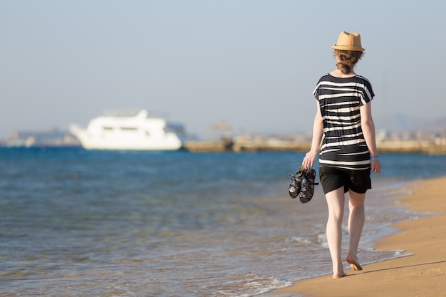 Junge Frau zu Fuß zu weißen Yacht