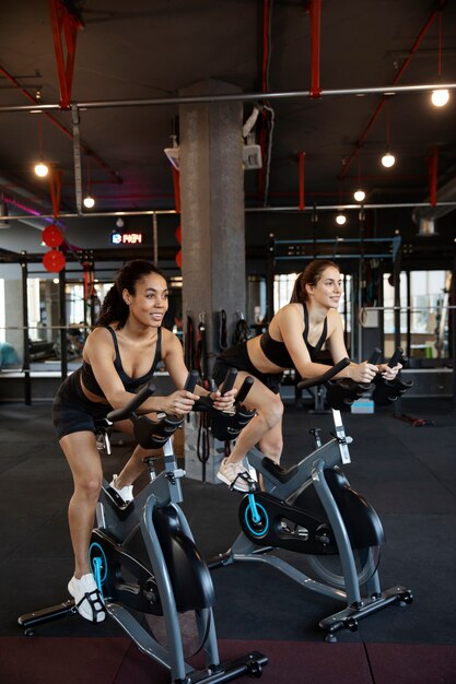 Junge Frauen, die am Spinning-Kurs teilnehmen