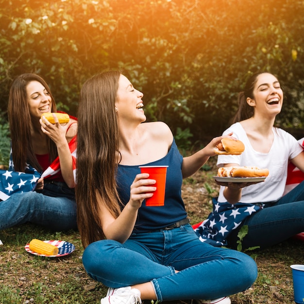 Kostenloses Foto junge frauen, die auf picknick lachen