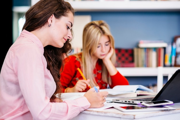 Junge Frauen, die bei Tisch studieren