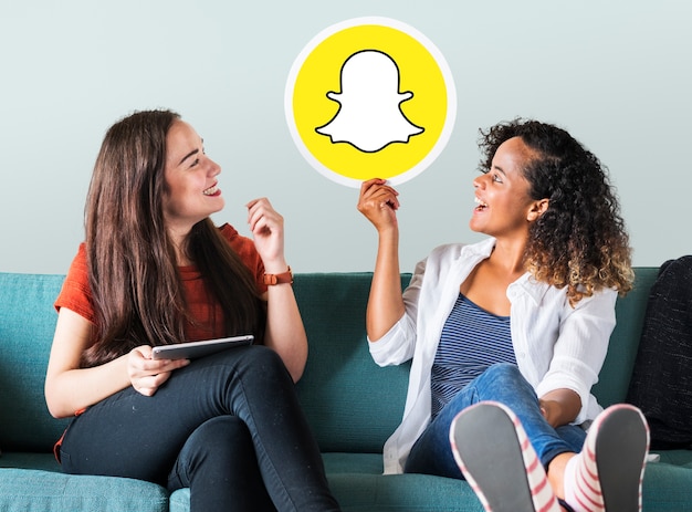Junge Frauen, die eine Snapchat-Ikone zeigen