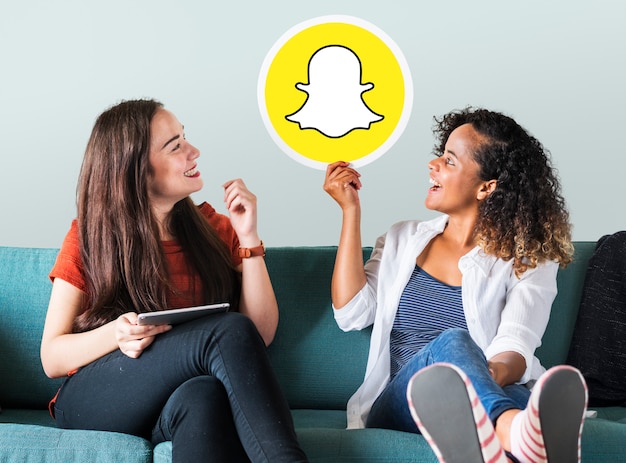 Junge Frauen, die eine Snapchat-Ikone zeigen