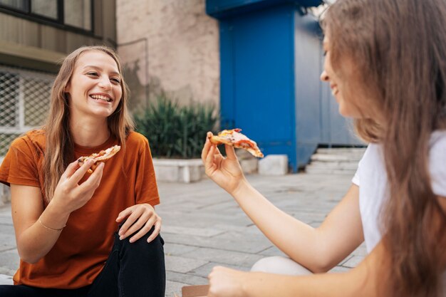 Junge Frauen, die zusammen Pizza essen