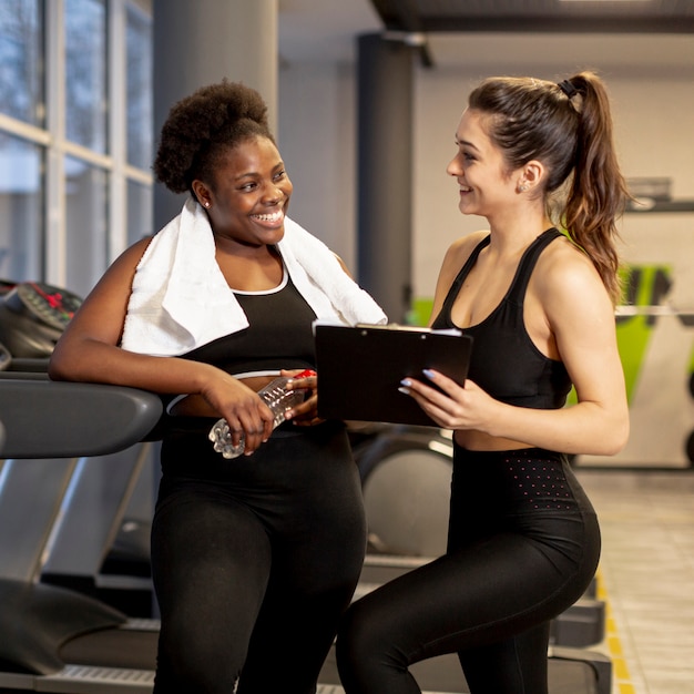 Junge Frauen im Fitnessstudio sprechen