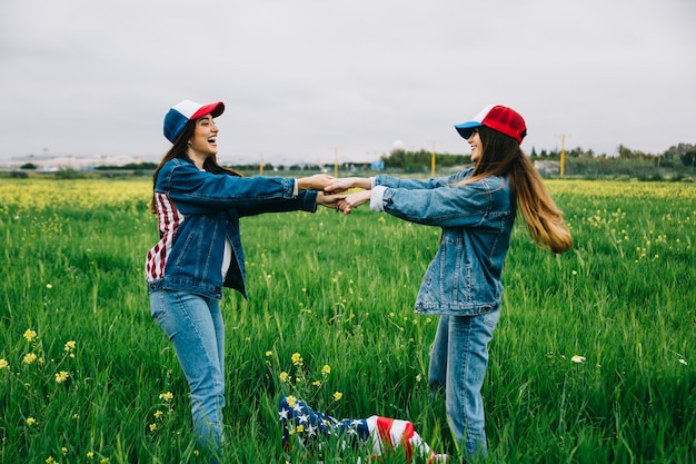 Junge Frauen in den Jeans kleiden das Lachen auf dem Gebiet