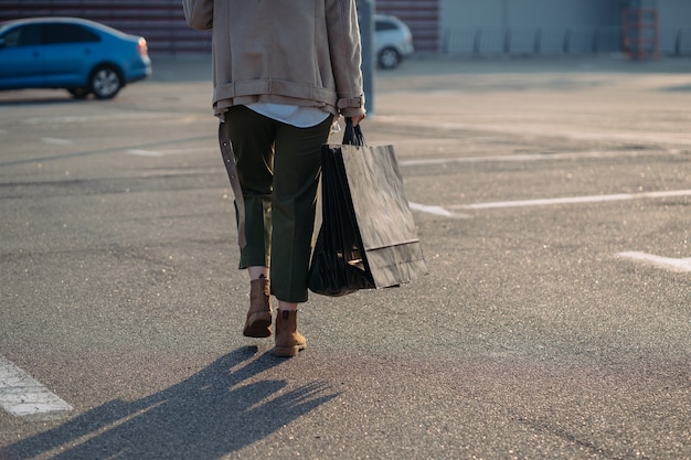 Junge Frauen mit Einkaufstaschen, die auf Straße gehen.