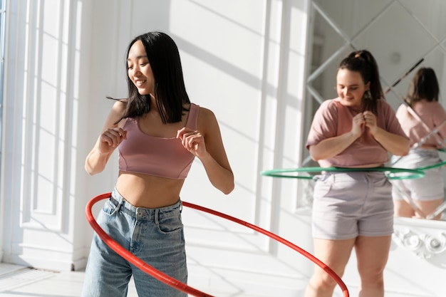 Kostenloses Foto junge frauen mit hula-hoop-reifen