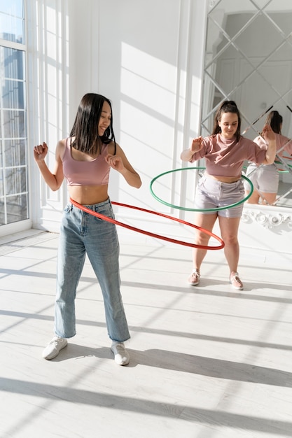 Kostenloses Foto junge frauen mit hula-hoop-reifen