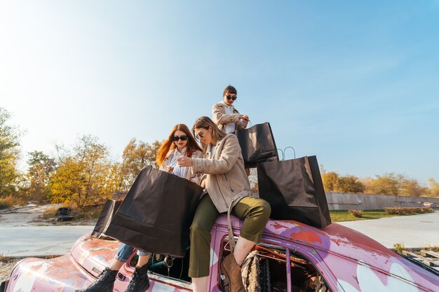 Junge Frauen posieren auf dem alten verzierten Auto