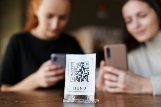 Kostenloses Foto junge frauen scannen qr-code in der cafeteria