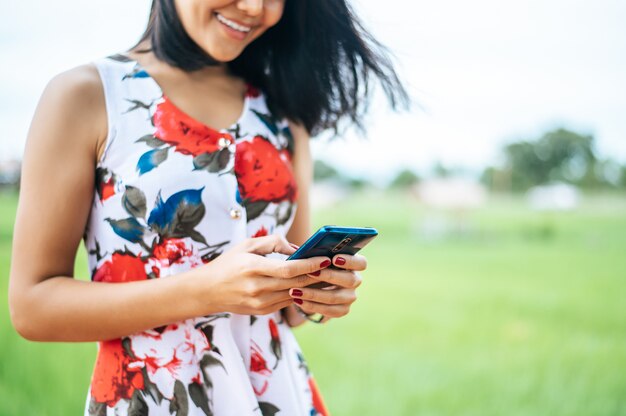 Junge Frauen tragen bunte Kleidung und spielen ein Smartphone