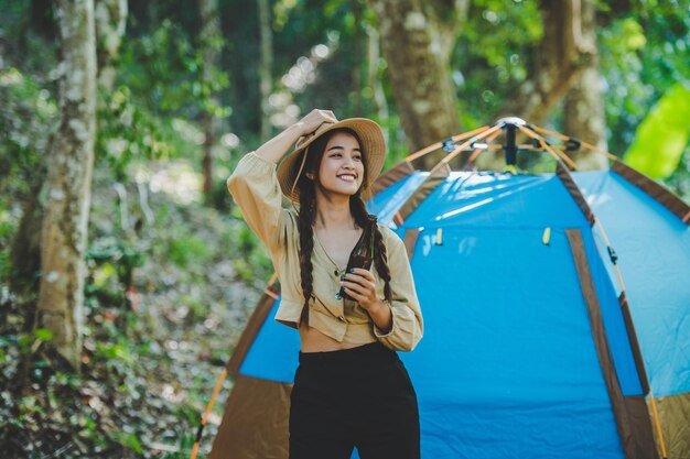 Junge Frauen und Freundinnen Reisende entspannen sich in Campingstühlen im Zelt Sie jubeln und trinken Bier während des Campings und reden mit Spaß und Freude zusammen