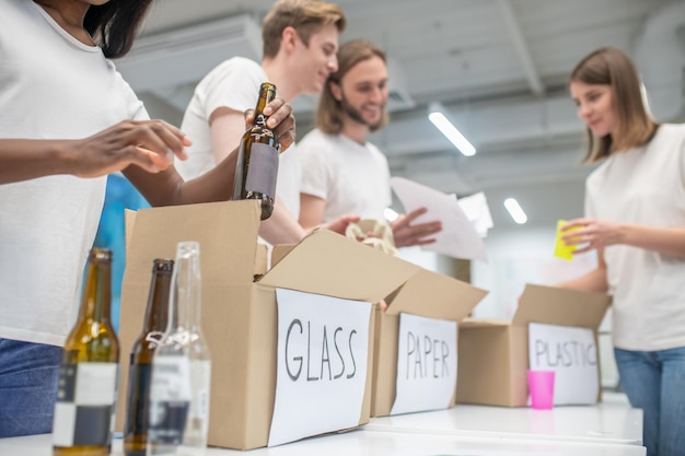 Kostenloses Foto junge freiwillige, die beschäftigt aussehen, während sie im recyclingzentrum arbeiten