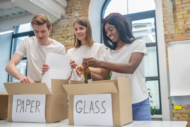 Junge Freiwillige, die beschäftigt aussehen, während sie im Recyclingzentrum arbeiten