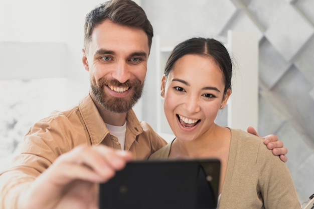 Junge freunde des modells, die selfies im büro nehmen