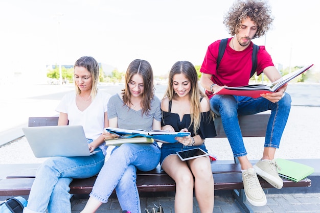 Junge Freunde, die auf Bank studieren