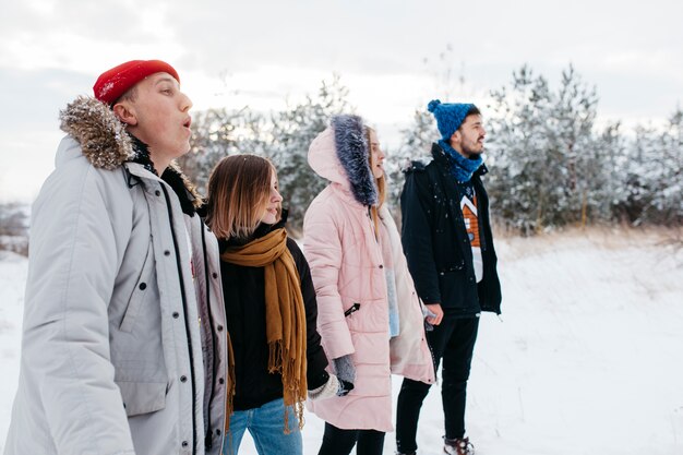 Junge Freunde, die Hände im Winterwald anhalten