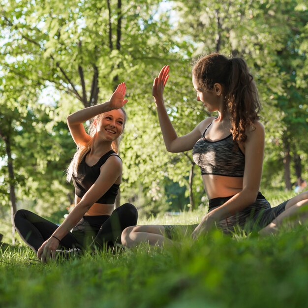 Junge Freunde, die Yoga im Park tun