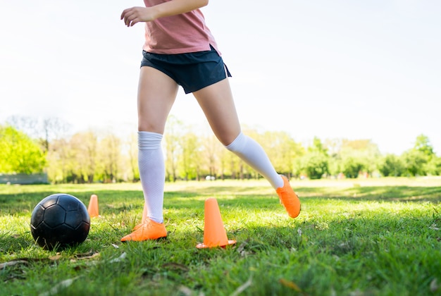 Junge Fußballerin, die auf dem Feld übt