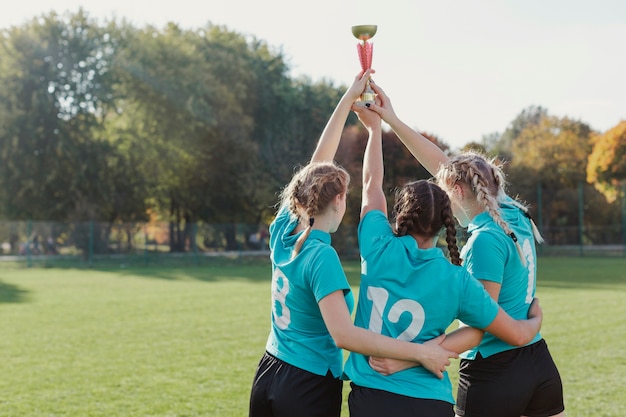 Junge Fußballspieler, die eine Trophäe anheben