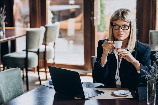 Junge Geschäftsfrau, die am Computer in einem Café arbeitet