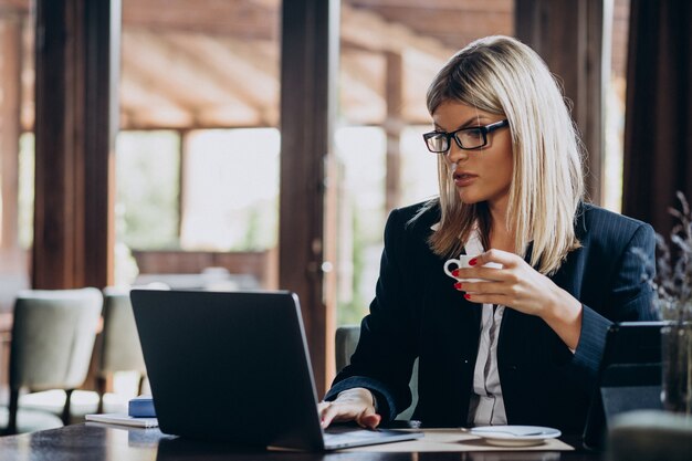 Junge Geschäftsfrau, die am Computer in einem Café arbeitet