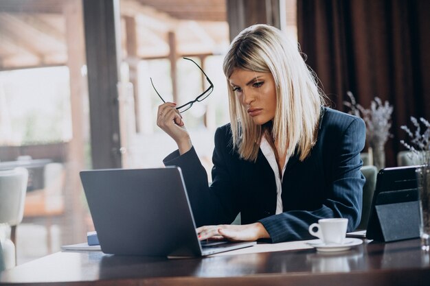 Junge Geschäftsfrau, die am Computer in einem Café arbeitet