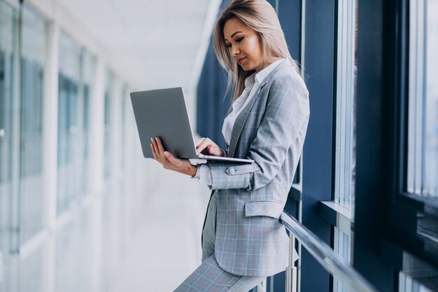 Junge Geschäftsfrau, die an Laptop in einem Computer arbeitet